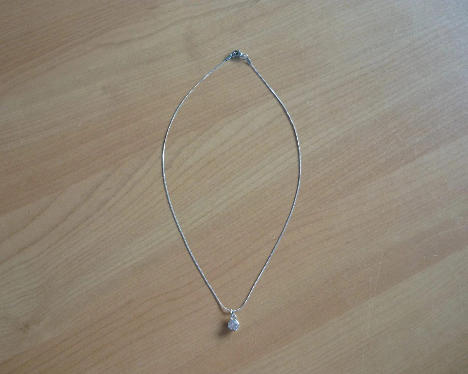 Zilverkleurige fijne schakel ketting met witte strasssteen hanger