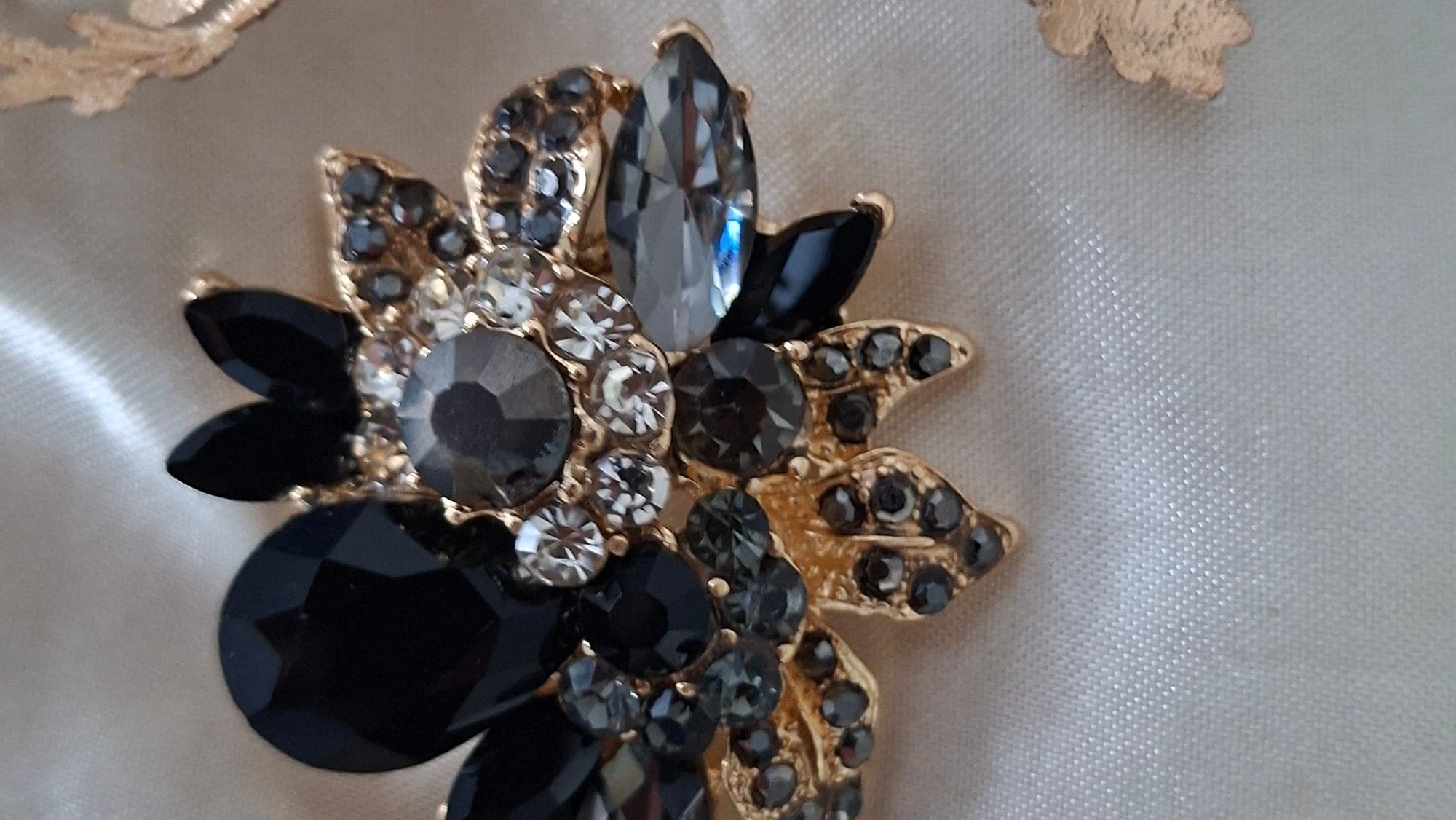 Vintage bloembroche met zwarte kristallen en goudtint