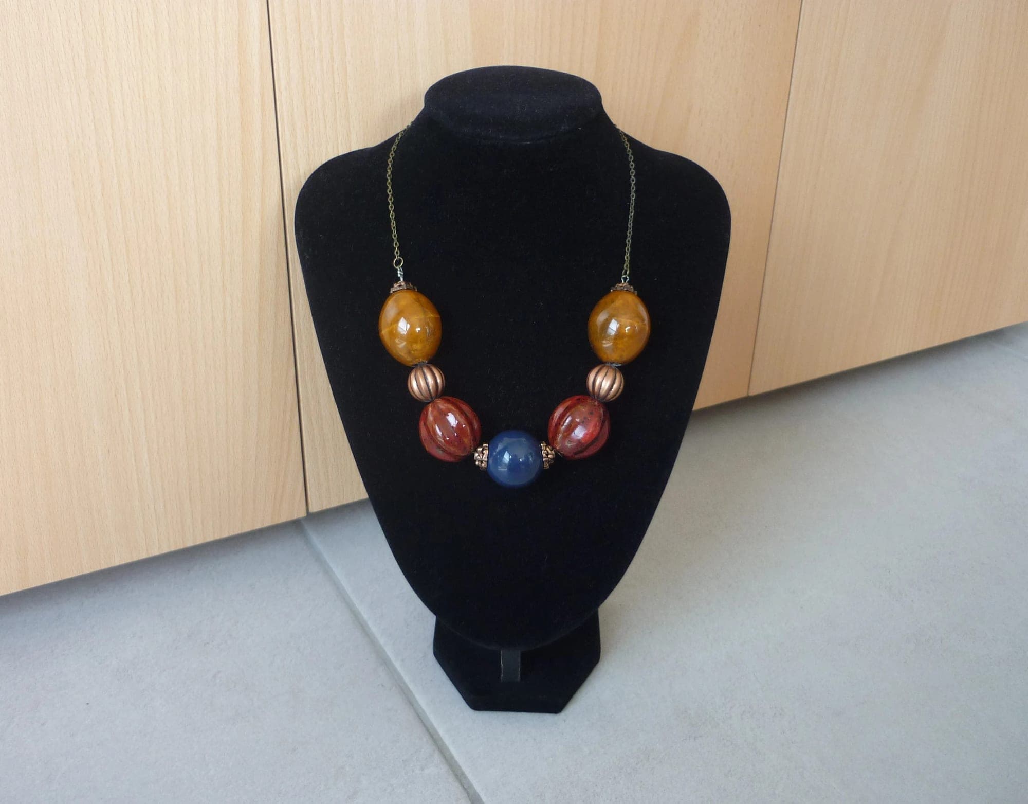 Bronskleurige ketting met grote bruine rode blauwe keramische bollen kralen