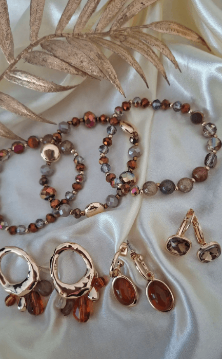Set van goudkleurige sieraden met bruine kralen en edelstenen