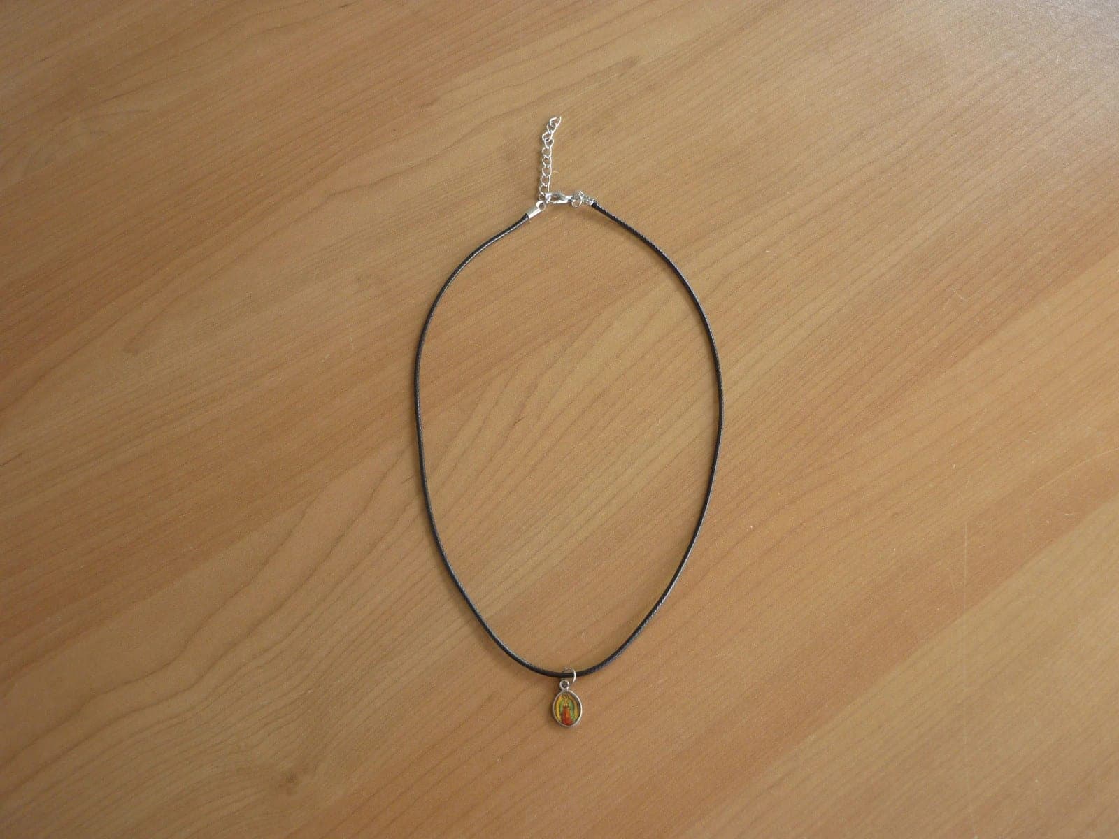 Zwarte touw ketting met zilverkleurige ovale Mariabeeld en kruis hanger