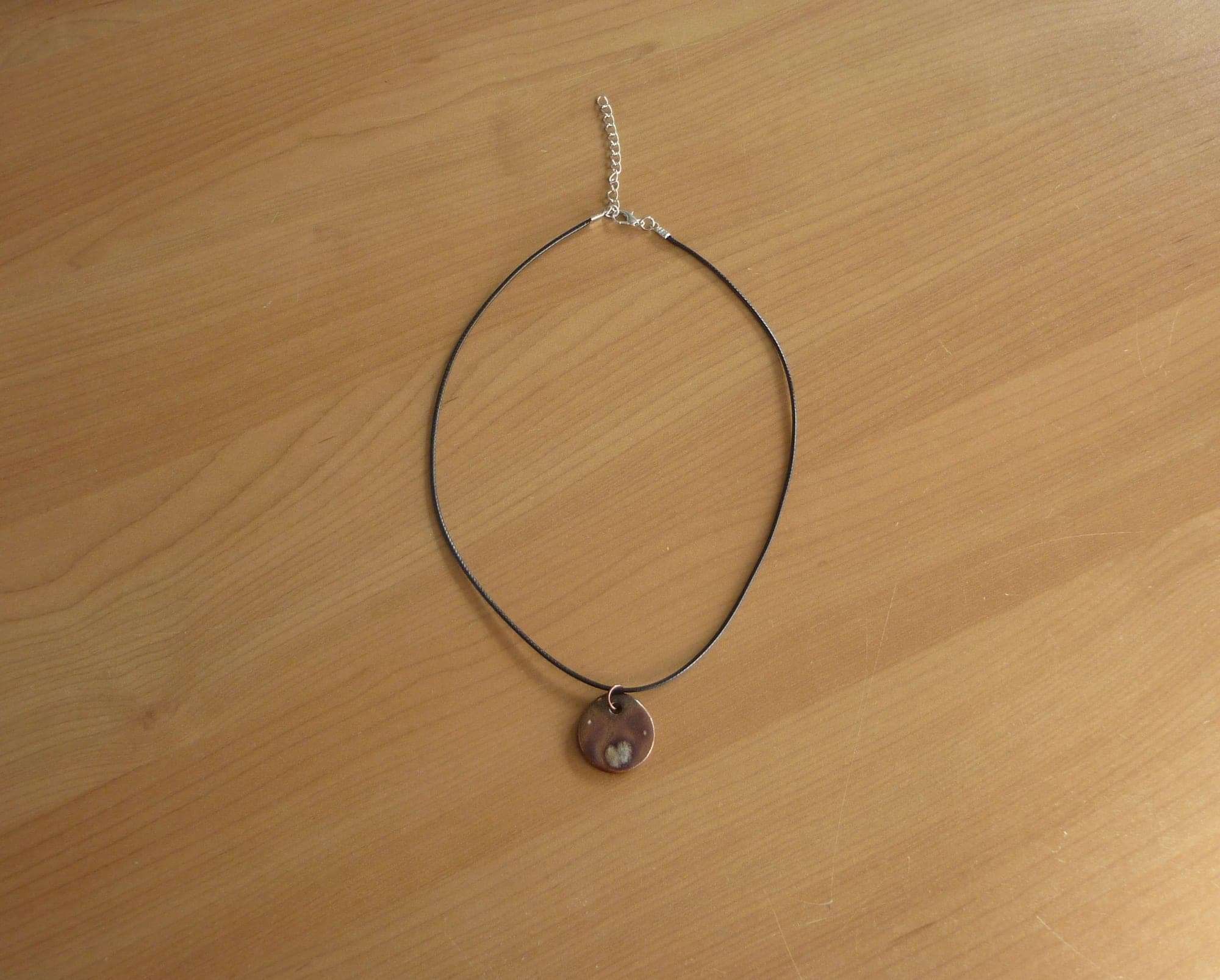 Zwarte touw ketting met bruin paarse keramische ronde hanger
