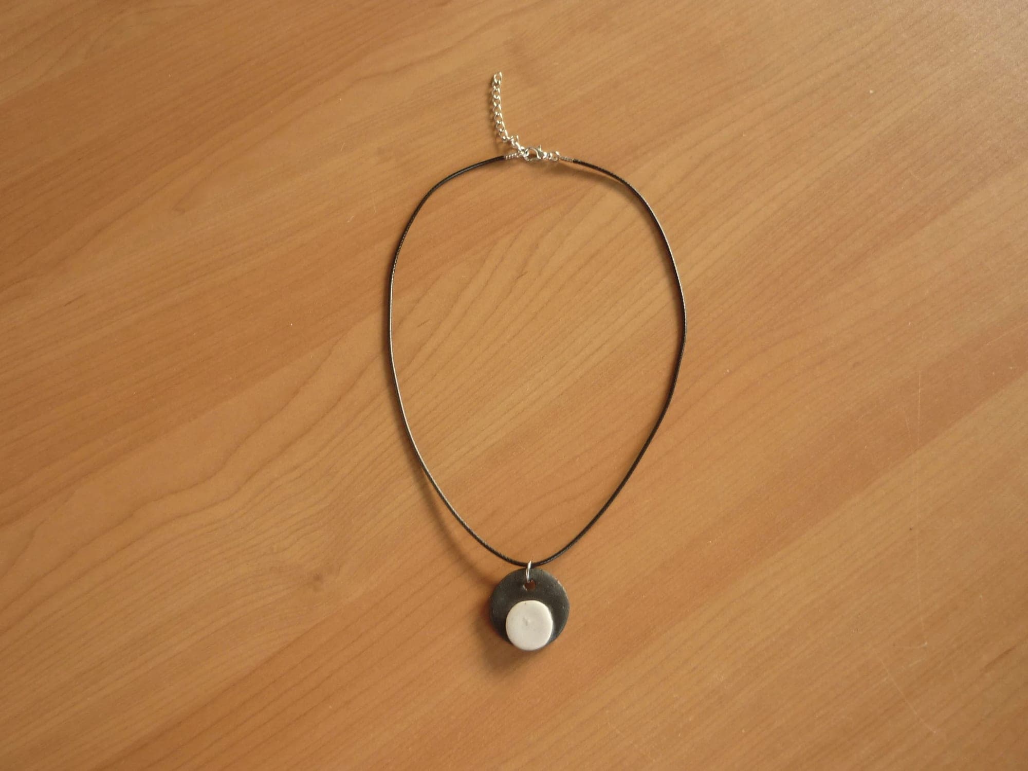 Zwarte touw ketting met zwart witte dubbele ronde hanger