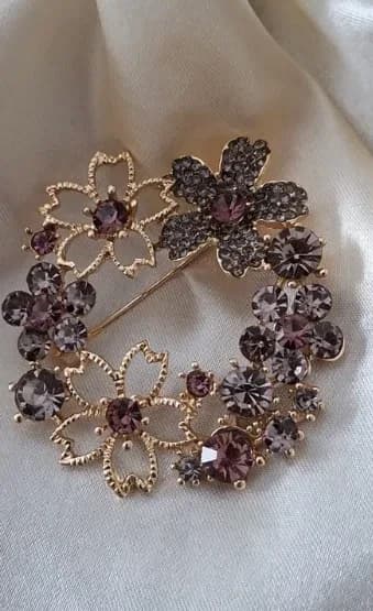 Goudkleurige bloemen broche met paarse kristallen