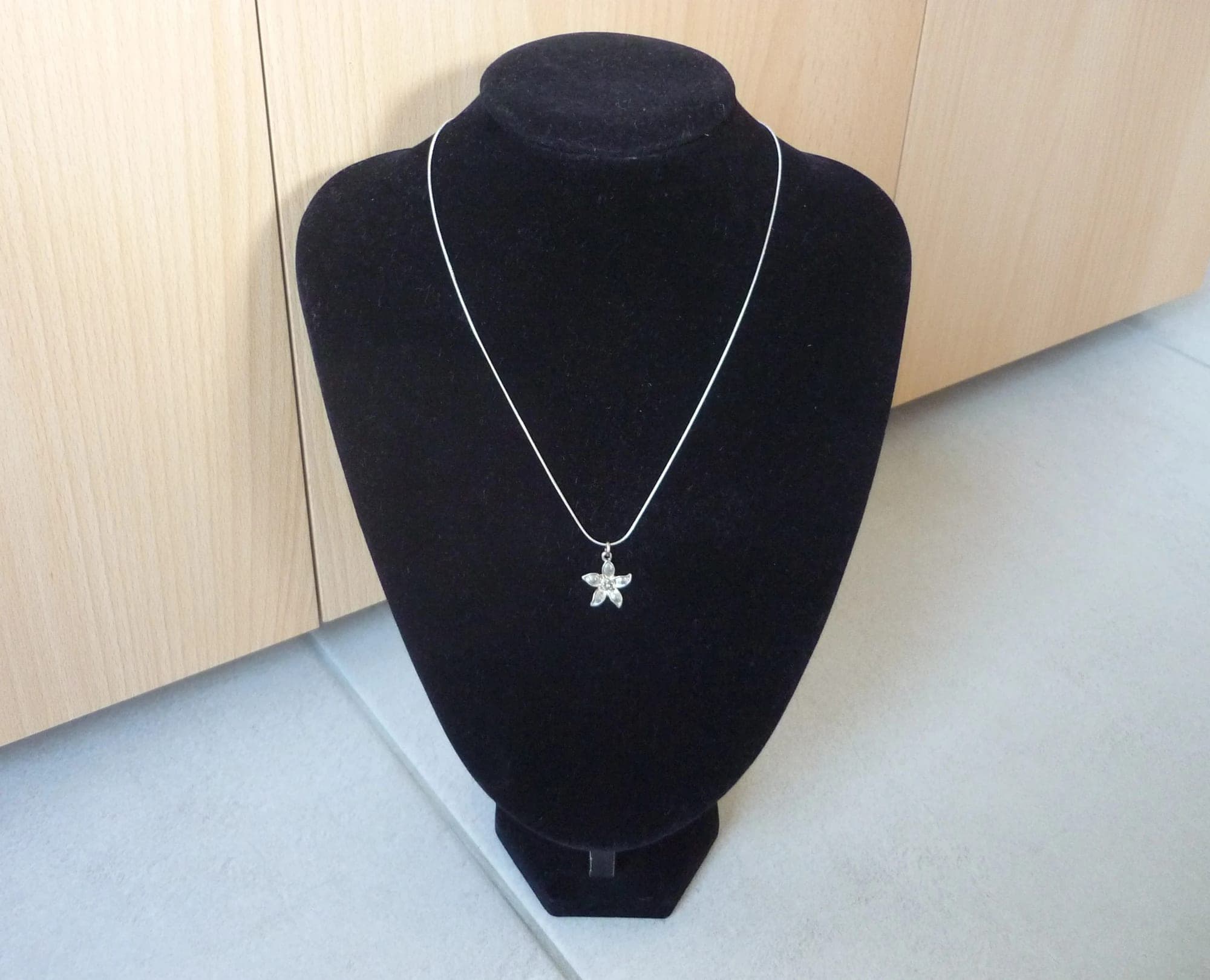 Zilverkleurige ronde ketting met zilverkleurige bloem hanger