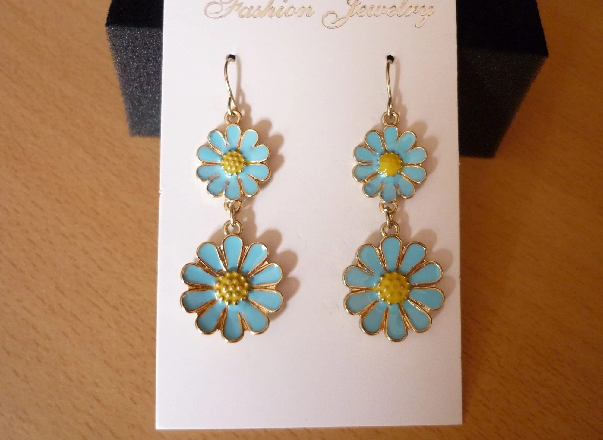 Goudkleurige lange oorbellen met blauwe bloemen