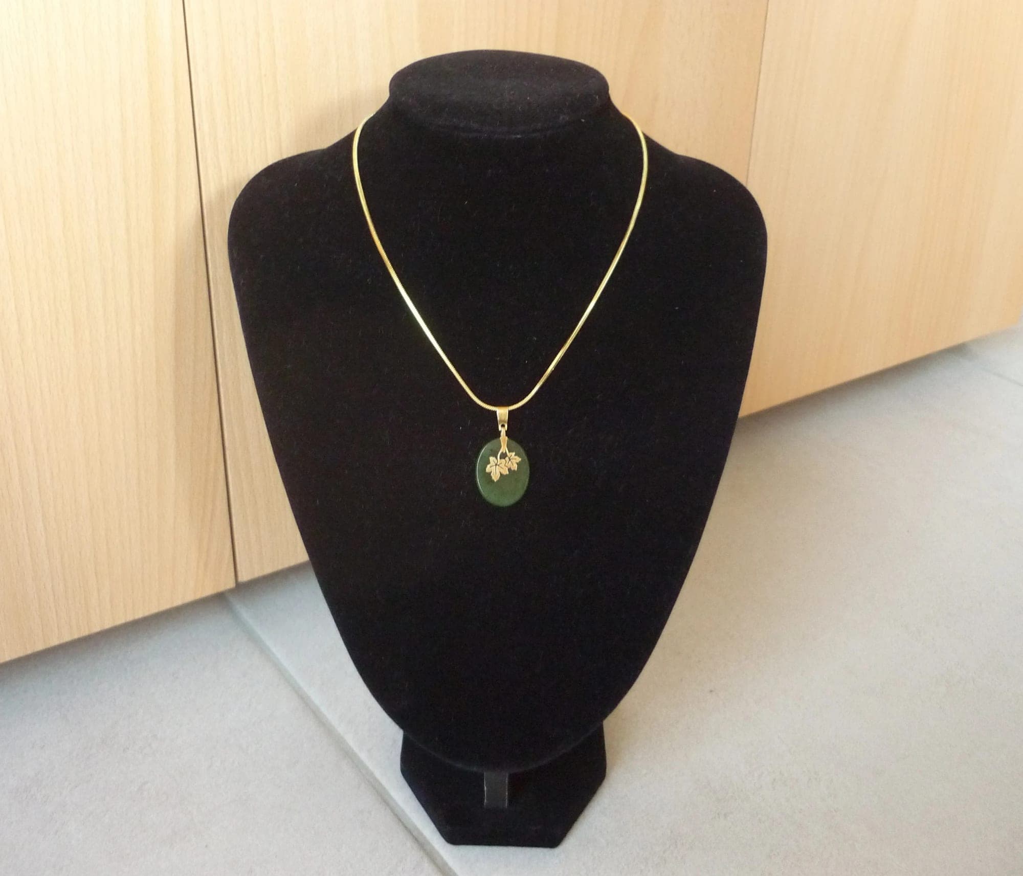 Goudkleurige ronde ketting met groene ovale hanger
