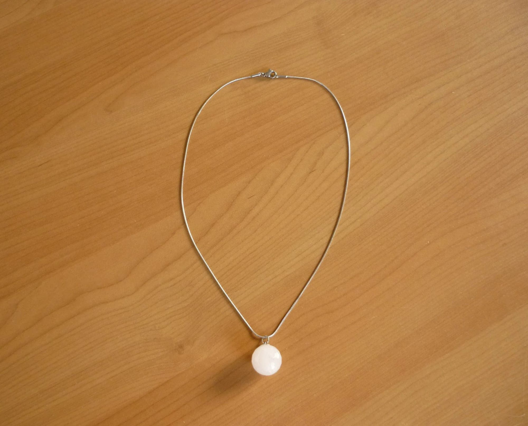 Zilverkleurige ronde ketting met lichtroze bol halfedelsteen hanger